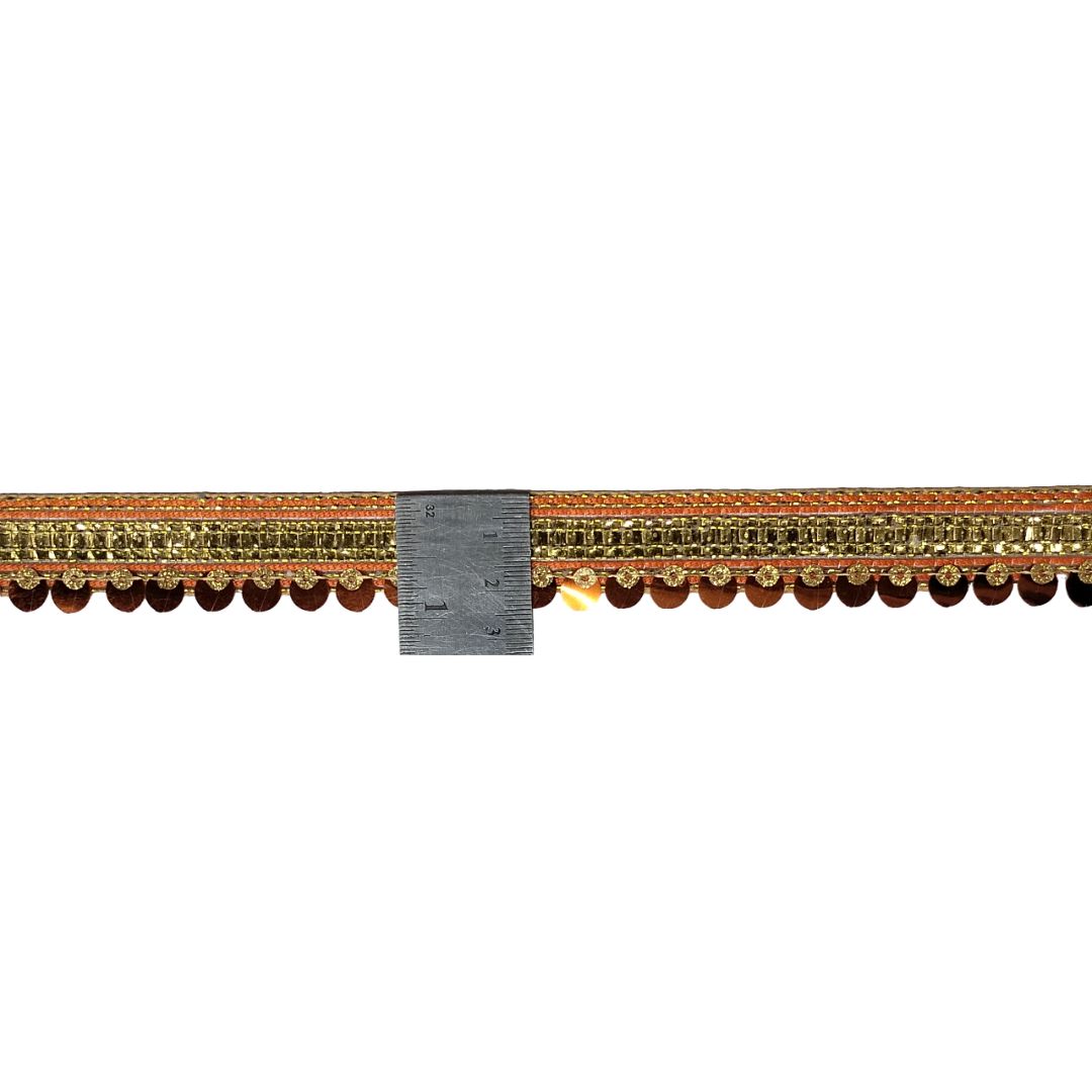 Decorative gold and brown trim with a ruler for scale on a white background